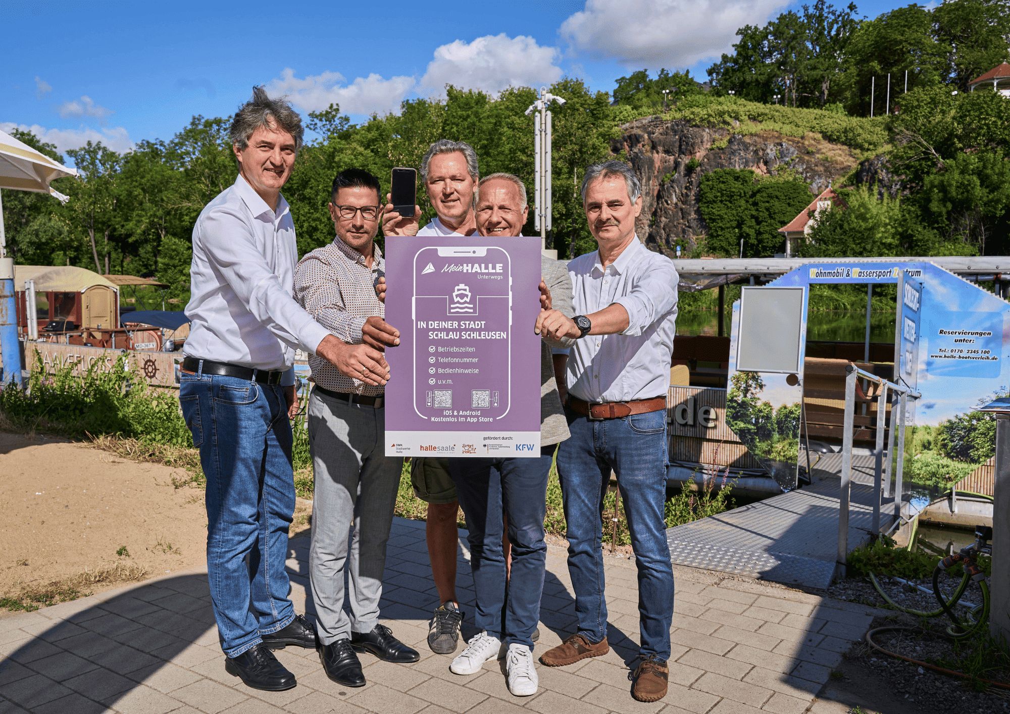 Matthias Lux (Stadtwerke Halle GmbH), Andreas Blümner (Stadt Halle (Saale)), David Hauff (Wassertouristik Saaletal), Mark Lange (Stadtmarketing Halle) und Peter Kolbert (Stadtwerke Halle GmbH) präsentieren die neuen Features der App (v.l.n.r.). © Stadtwerke Halle GmbH